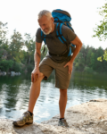 Male hiker experiencing knee, hip, and back pain while hiking.