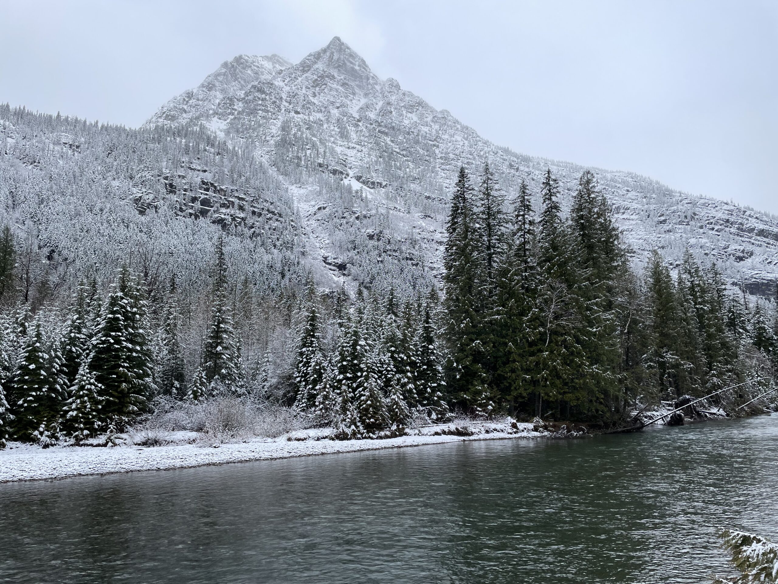 Snow blankets the mountains above McDonald Creek